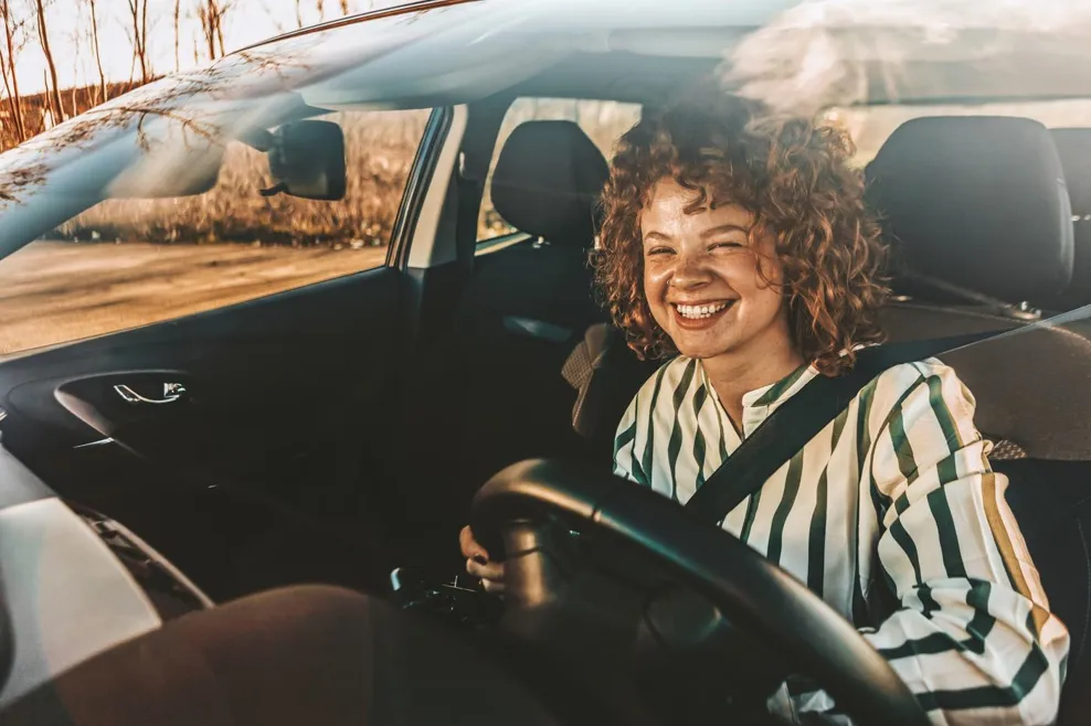 Young woman driving a car, smiling