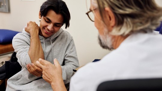 Doctor examining patient's arm during appointment