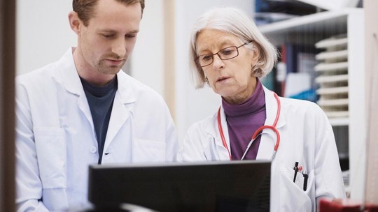 two medical professions looking at a computer screen