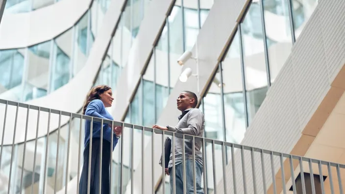 Man and woman meet on the skywalk bridge in Tietoevry office