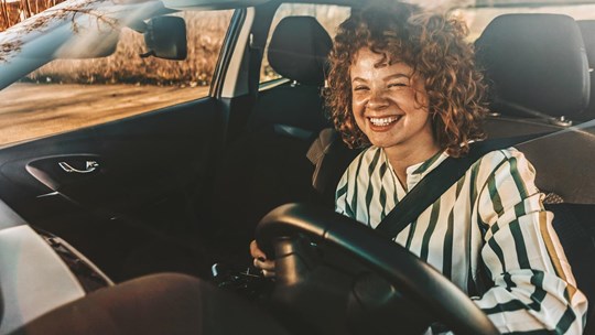 Young woman driving a car, smiling