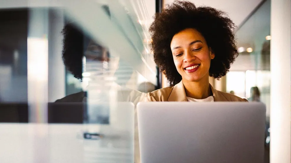 Young woman in online meeting on laptop smiling