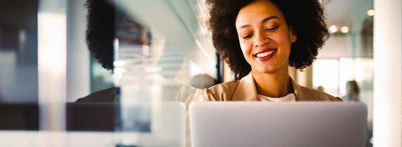 Young woman in online meeting on laptop smiling